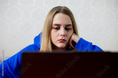 Canvas Print Blonde girl forced to work remotely stares at laptop without interest