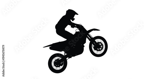 Motocross rider performing a wheelie a dramatic black silhouette