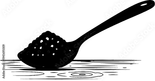 Perforated spoon holding a pile of small dark particles, casting shadows
