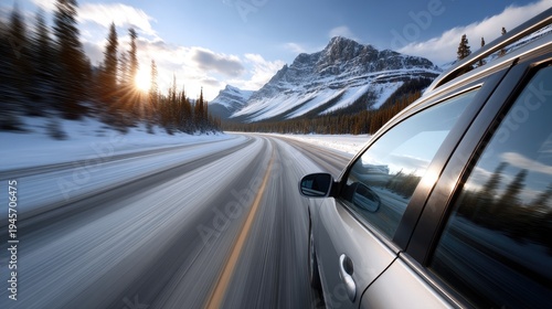 A silver SUV moves quickly along the highway while mountains blur in the background under a clear blue sky