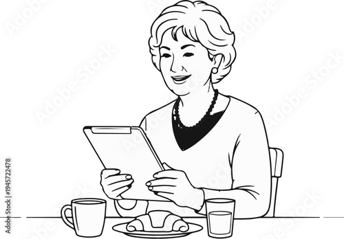 Woman smiling at tablet while eating breakfast at table