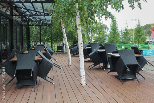 Modern cafe on wooden deck with black wicker furniture