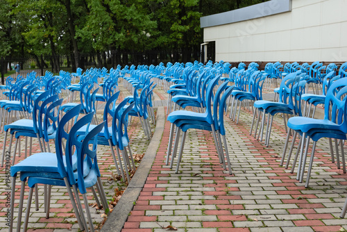Rows of blue chairs line a paved courtyard