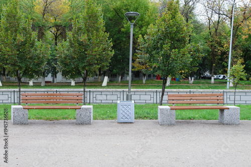 Two wooden benches flank a paved walkway