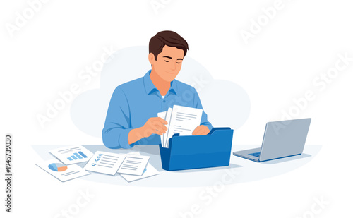 Man organizing documents in a folder with charts and laptop on desk. A focused man in a blue shirt sorts papers into a blue file folder, surrounded by reports and a laptop
