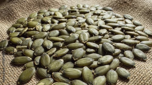 Close up of shelled pumpkin seeds on a burlap surface