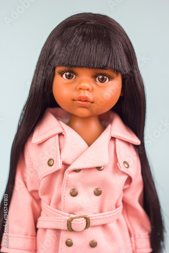 Beautiful Realistic vinyl mulatto doll in fashionable and stylish clothes, modern dolls for modern children, selective focus