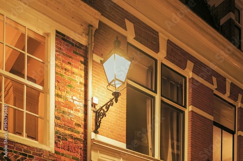 Street lamp illuminating historic building facade at night in leeuwarden