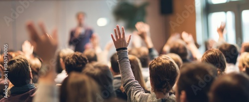 The audience raising hands during an interactive seminar in a modern conference room