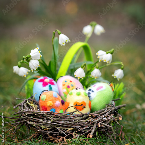 fresh flowers and easter eggs in a nest on the meadow