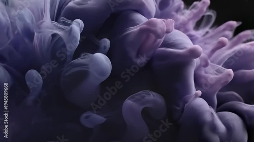 Abstract swirls of purple and gray ink in water creating a floral form