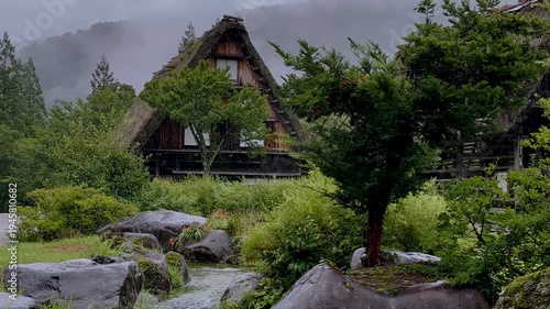 4K Cinematic video of traditional Gassho-zukuri house in Shirakawa-go with rainy atmosphere and sound of flowing water