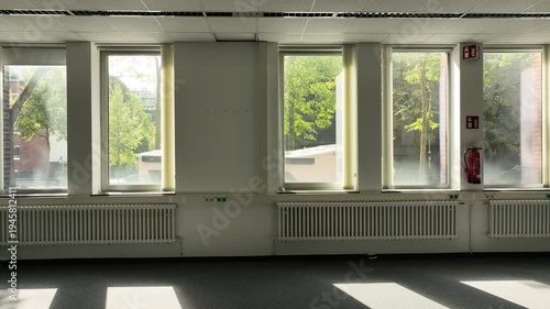 Spacious, vacant office with glass partitions, ideal for commercial real estate, architecture, and business concepts. 
