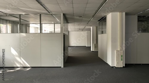 Spacious, vacant office with glass partitions, ideal for commercial real estate, architecture, and business concepts. 
