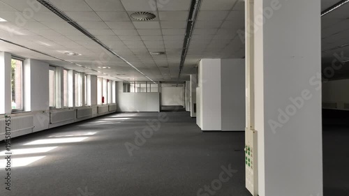 Spacious, vacant office with glass partitions, ideal for commercial real estate, architecture, and business concepts. 
