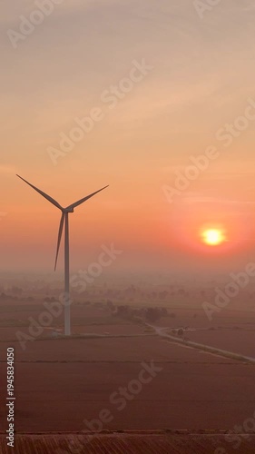 Aerial view of Wind turbines Energy sunrise. Wind turbines at sunrise in heavy fog. Wind farm generating green energy. Environment friendly renewable energy concept.