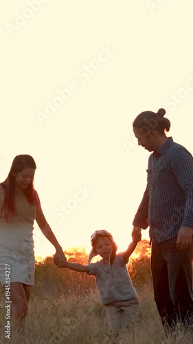 Family with son walking on field on wind farm. Happy Family and son playing at the Wind turbines generating electricity. Family time together.