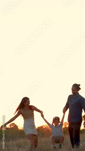 Family with son walking on field on wind farm. Happy Family and son playing at the Wind turbines generating electricity. Family time together.