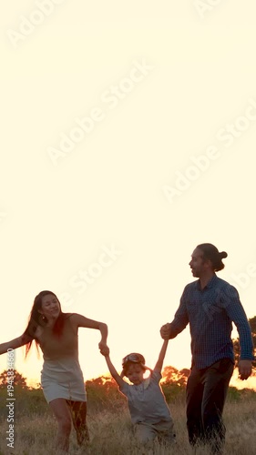 Family with son walking on field on wind farm. Happy Family and son playing at the Wind turbines generating electricity. Family time together.