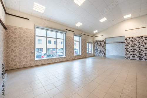 Tableau sur toile Spacious Interior of an Empty Commercial Space With Large Windows and Tiled Floo