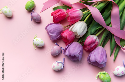 Colorful easter eggs and spring tulips on a pink background