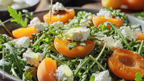 Fresh salad with apricots and cheese in a bowl on a wooden table