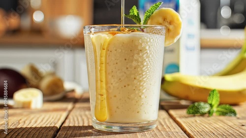 Fresh smoothie with banana and honey on wooden table