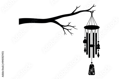 Black silhouette of a wind chime hanging from a bare tree branch