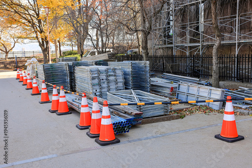 Steel railinga pile of building materials, scaffoldings Waiting for assembly on construction site. along the park walkway.