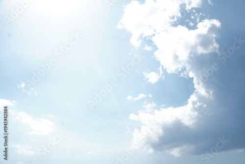 Φωτογραφία High-key photograph of a blue sky filled with bright, hazy sunlight and a large, towering cumulus cloud formation
