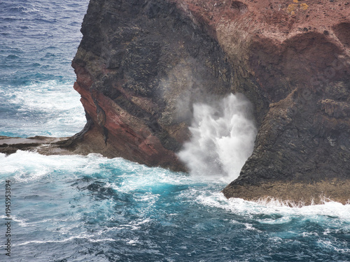 Photography Wave Explosion in Volcanic Sea Cave - Dynamic close-up of a powerful ocean wave crashing into a volcanic sea cave or blowhole in Madeira, creating a dramatic spray of white water
