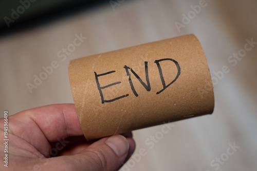 Foto A person holding a cardboard tube with the handwritten word END displayed prominently
