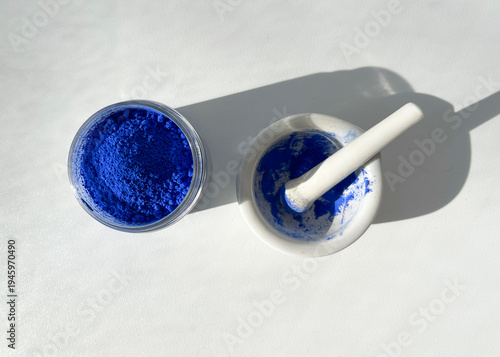 Pigments for painting. Ultramarine pigment in a jar and a mortar for grinding pigments. The remains of the pigment in the mortar.