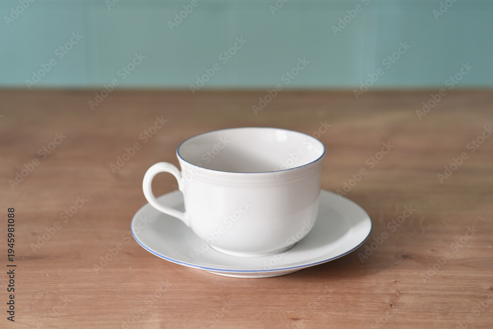 Obraz premium White porcelain cup on wooden background in kitchen