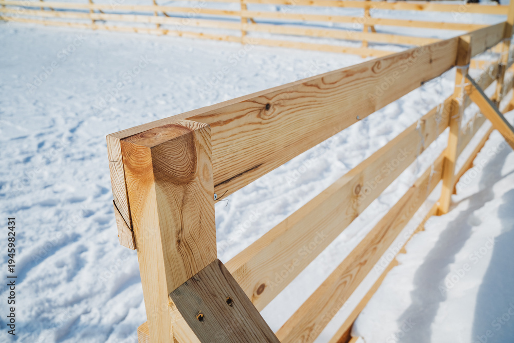 Fototapeta premium Geometric Fence Casting Shadows. Snowcovered Ground With Textured Wooden Fence. Minimalist Scene Showing Timber Fence Shadows On Smooth Snow With Detailed Grain And Angled Joints
