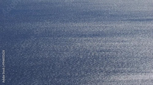 Close view of sunlight shimmering across wind ripples on the surface of the Aegean Sea near Kea Island in Greece, creating a sparkling ocean texture in natural Mediterranean light.