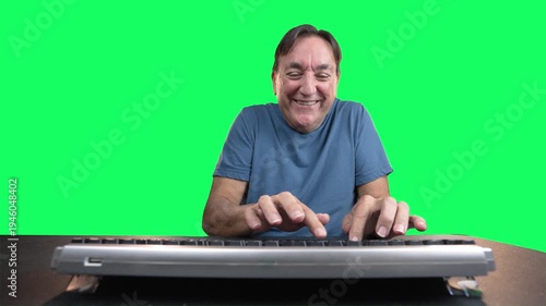 Smiling man aggressively typing on computer keyboard on green screen background. Humorous concept of online trolling, keyboard warrior behavior, or excited internet posting. 15092  