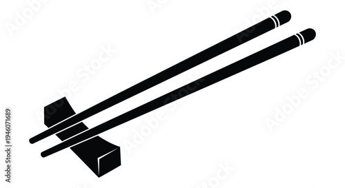 A pair of black chopsticks resting on a small dark rectangular stand