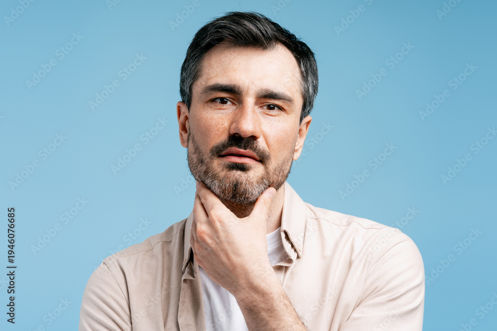 Fototapeta premium Man in deep thought touching beard, contemplating future decisions and ideas
