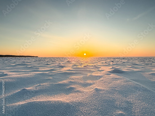 Wind shaped snow texture at sunset with copy space