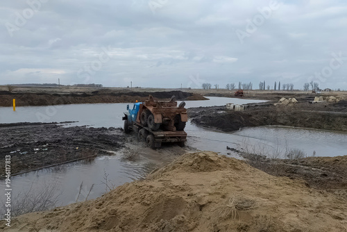 Bild auf Leinwand Transportation of the carriers chassis on a truck on flooded ground