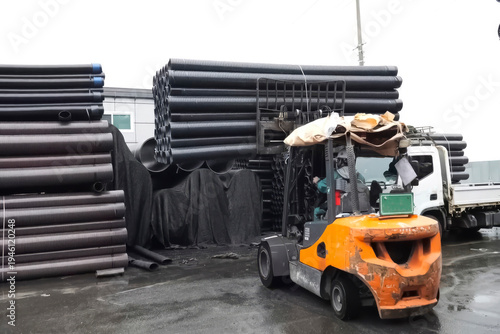 Forklift loading polypropylene pipes in warehouse