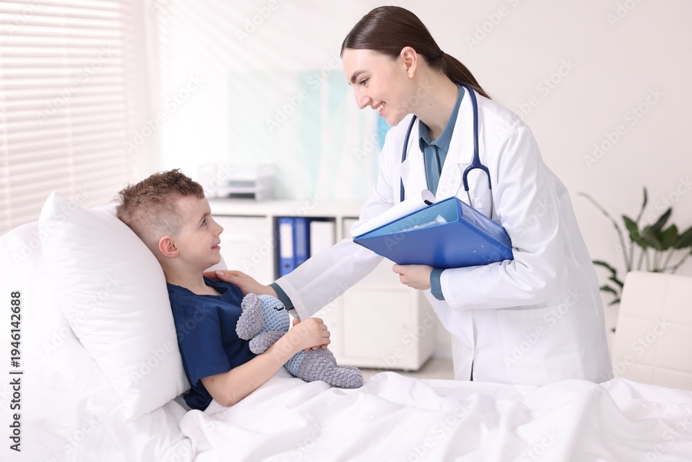 Obraz premium Doctor with folder examining little child in hospital