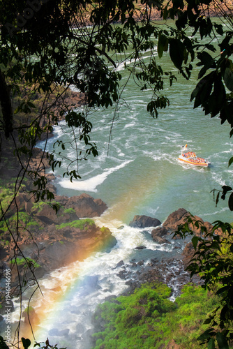 waterfall in the forest with a rainbow and a boat