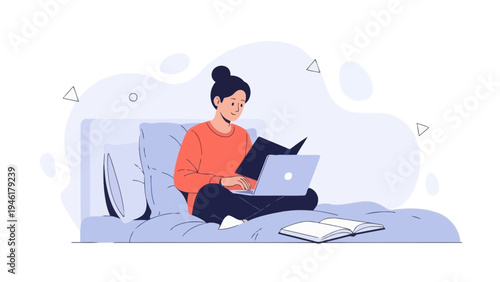 Young woman reading a book and using a laptop while sitting on a bed
