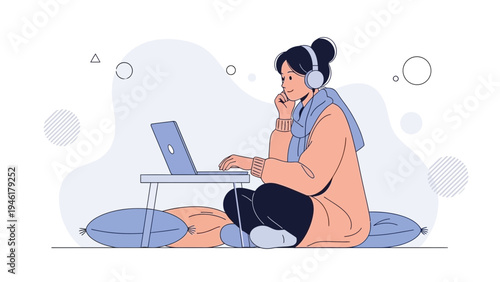 Young woman in headphones working on laptop, sitting on floor with pillows