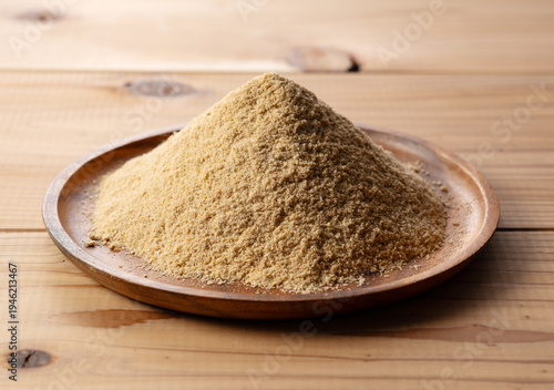 Pile of fresh organic rice bran powder on a wooden plate, natural background