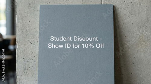 A sign offering a student discount on a concrete wall