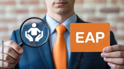 Professional man in suit and orange tie holds a magnifying glass showing employee support icon and an EAP card symbol