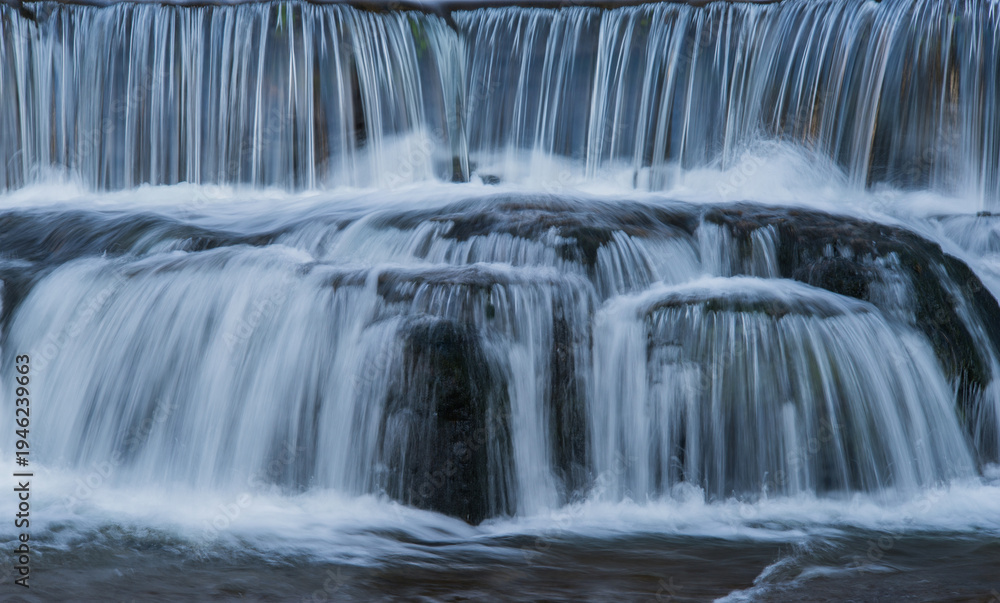 Obraz premium 段々のある滝を滑らかな水の流れが白い流れ模様として見られる風景